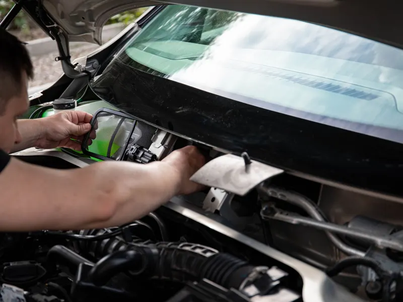 Mechanic working under the bonnet of a vehicle.